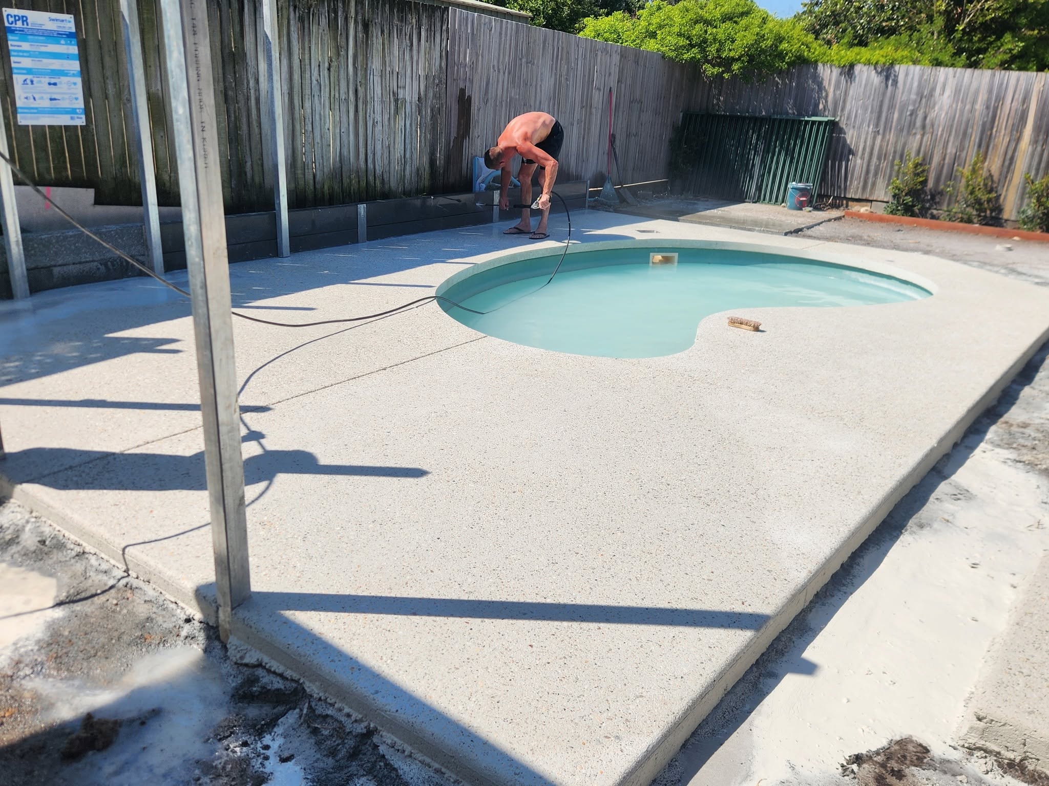 Exposed aggregate pool surround around a kidney-shaped pool